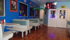 Un interior de restaurante con cabinas y una zona de bar.