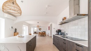 Uma cozinha moderna com ilha de mármore, armários de madeira e backsplash revestido de azulejos.