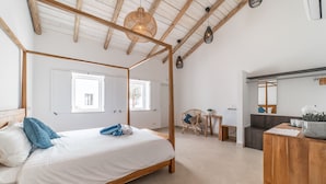 Quarto com uma cama de dossel, uma escrivaninha de madeira e uma cadeira.