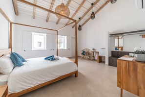 Quarto com uma cama de dossel, uma escrivaninha de madeira e uma cadeira.