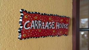 A wall sign with the text 'CARRAGE HOUSE' in a stylized font.