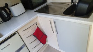 A compact kitchen with a microwave, toaster, and sink. - Relaxing couples getaway with hot tub (Congleton)