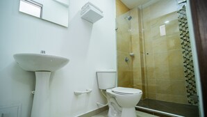 Ein Badezimmer mit Standwaschbecken, Toilette und einer Duschkabine.