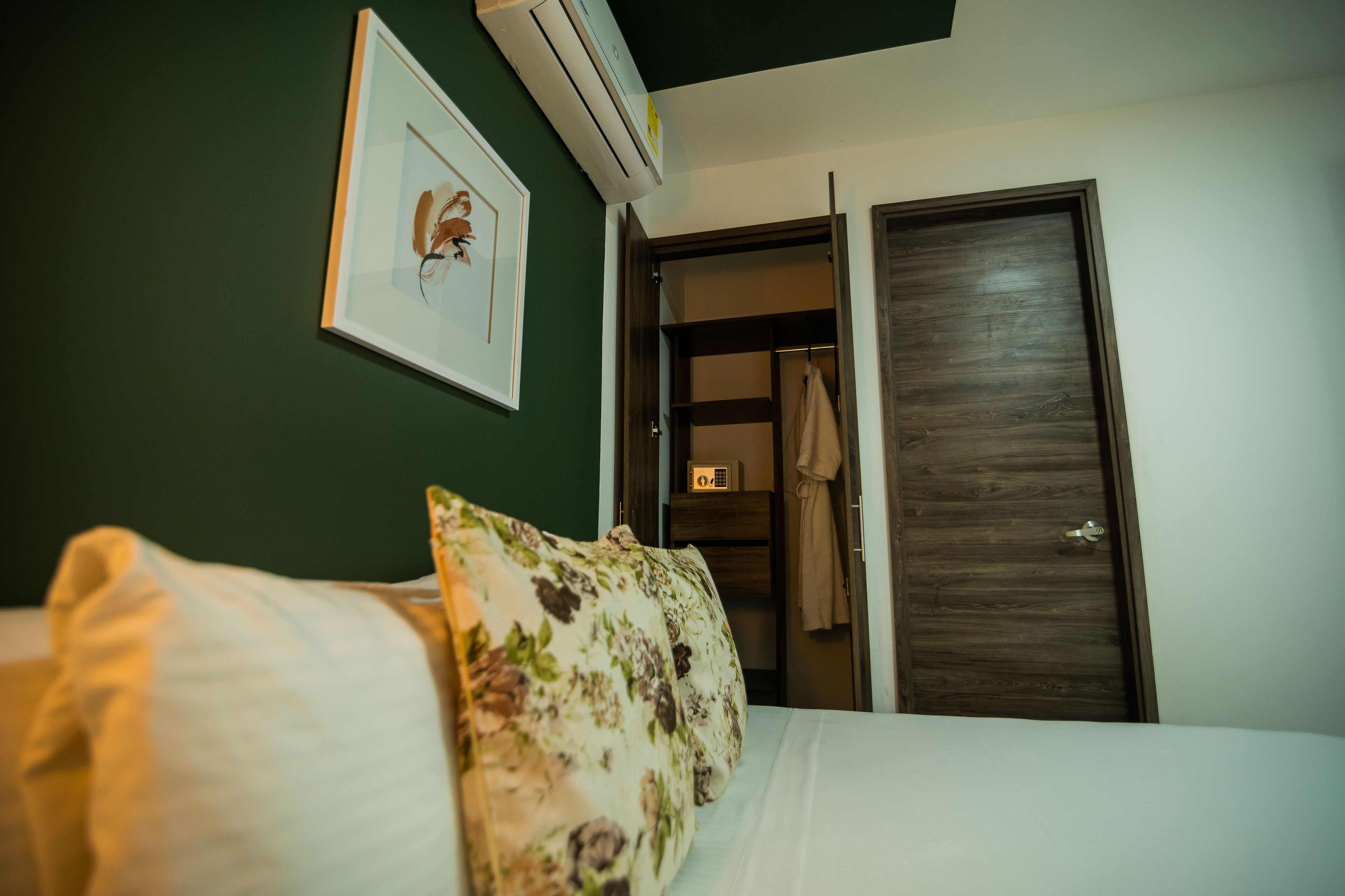 Ein Hotelzimmer mit einem Bett, einem gerahmten Bild an der Wand und einem Kleiderschrank.