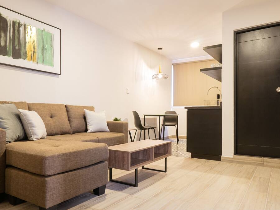 Una sala moderna con un sofá, una mesa de centro y un cuadro en la pared.
