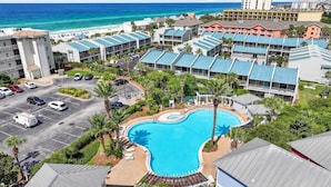 Ein Resort mit Schwimmbad, Zugang zum Strand und mehreren Gebäuden mit blauen Dächern.
