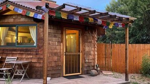Una cabaña de madera con un porche, una puerta y una ventana.