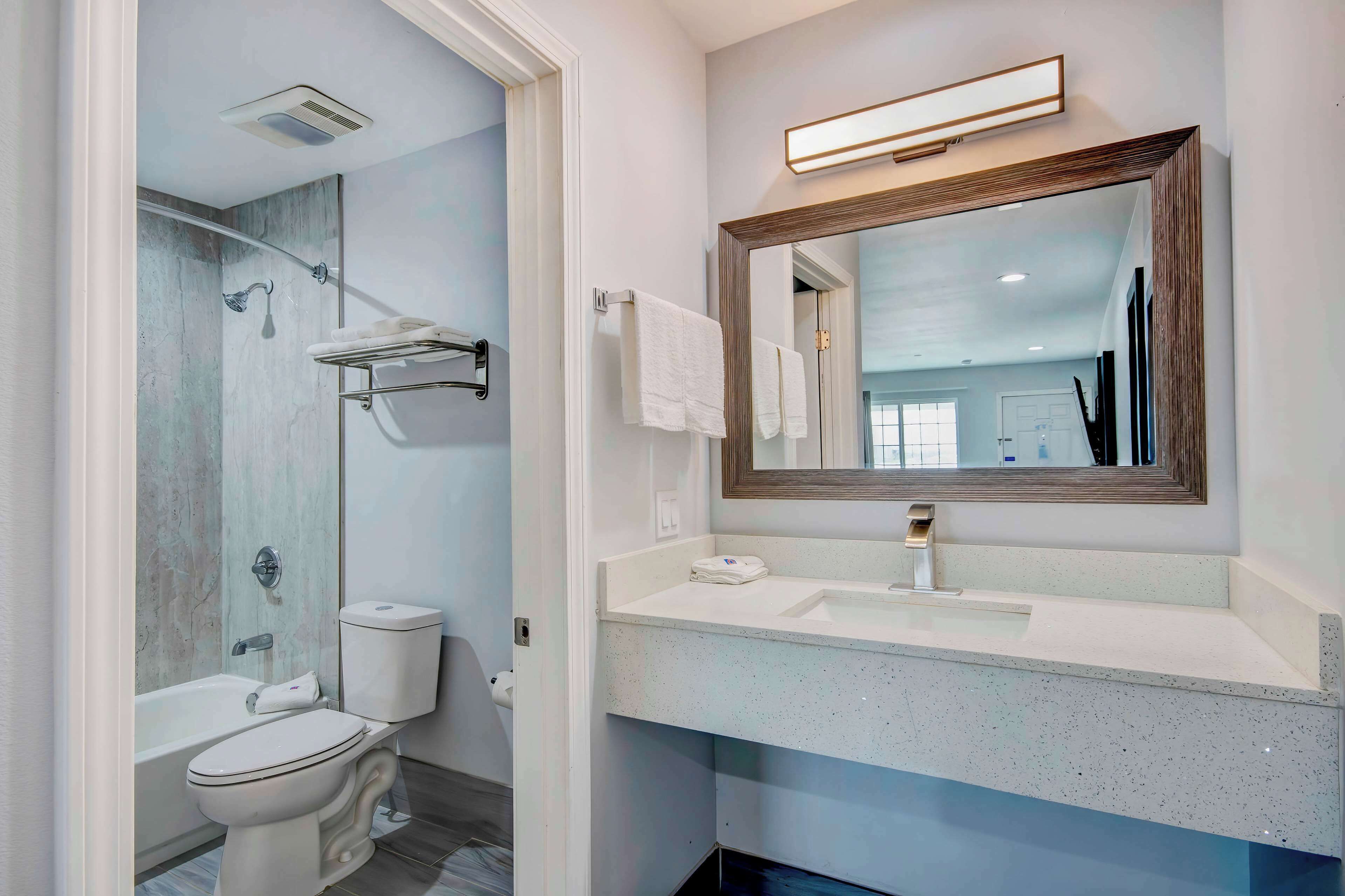 A modern bathroom with a bathtub, toilet, and sink.