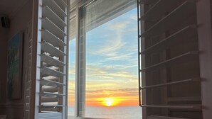 A room with a window overlooking a sunset. - Spectacular direct ocean front condo with amazing views of the Atlantic (Satellite Beach)