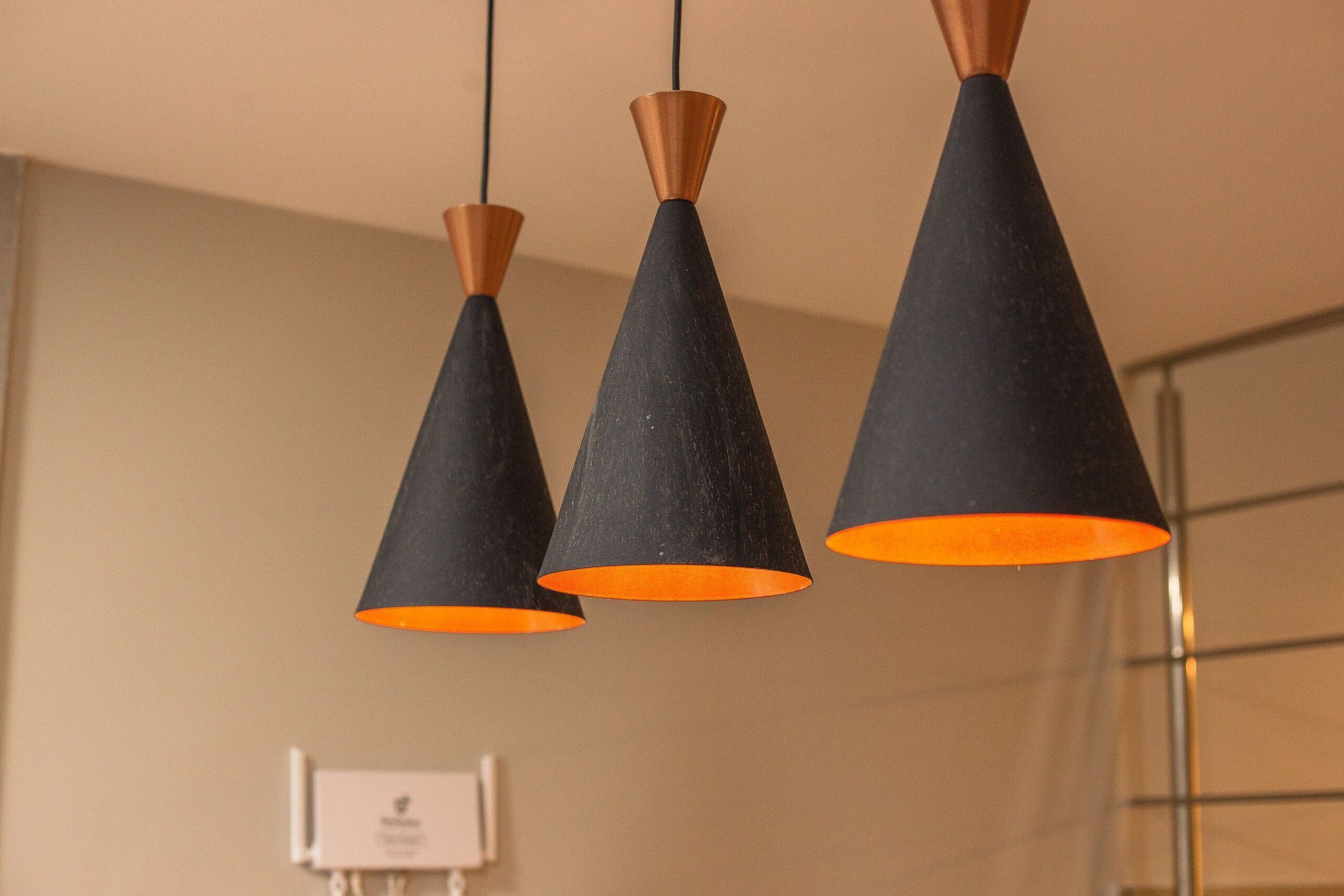 Three black pendant lights with copper-colored tops hanging from the ceiling.