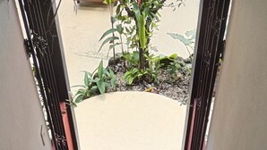 A staircase with black steps and handrails, leading to an outdoor area with plants. - Massai Apartments - Standard Suite (Playa Flamingo)