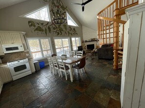 Eine geräumige Küche mit Essbereich, Kamin und einer Treppe zu einer weiteren Ebene.
