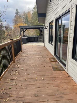 Eine Holzterrasse mit einer Pergola und einem Grillbereich.