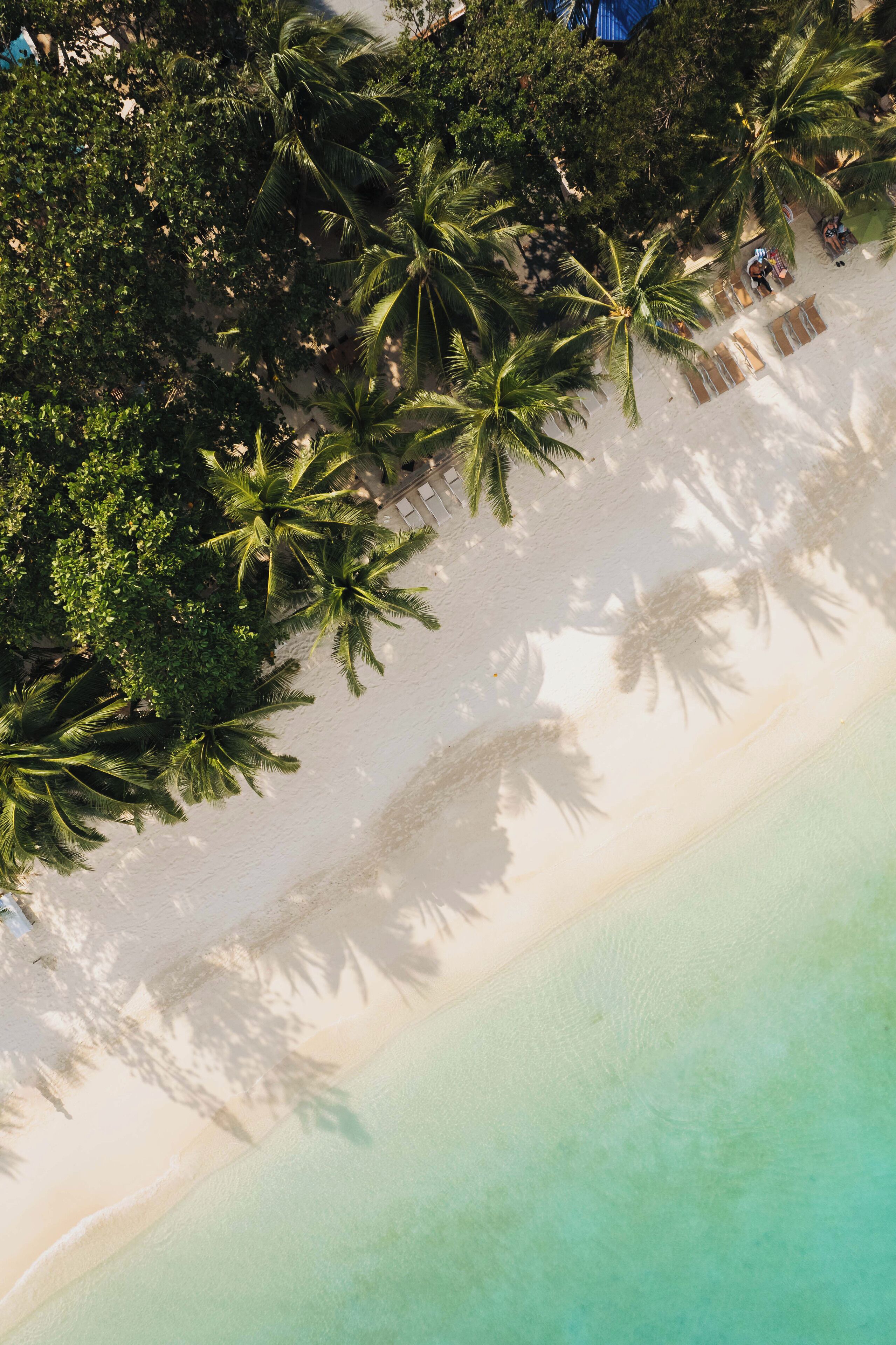 On the beach, white sand, sun-loungers, beach towels