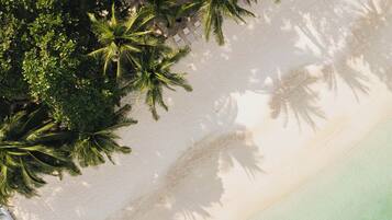 On the beach, white sand, sun-loungers, beach towels