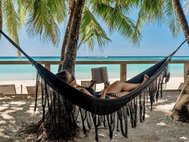 På stranden, vit sandstrand, solstolar och strandhanddukar