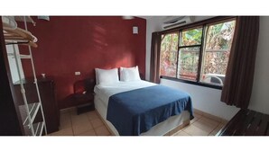 A room with a bed, a window with curtains, a radiator, and a wardrobe. - Massai Apartments #4 sleeps 5 (Playa Flamingo)
