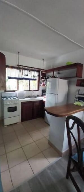Eine Küche mit Herd, Kühlschrank und Holzschränken.