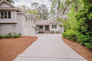 A two-story house with a front porch, a driveway, and a well-maintained lawn.