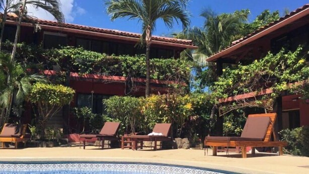 Un área de piscina con sillas de descanso y una piscina con azulejos.
