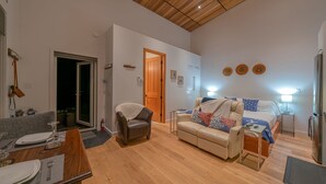 Uma sala de estar moderna com teto de madeira, um sofá, uma mesa de centro e um espaço de jantar com mesa e cadeiras.