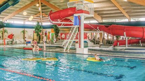 Piscina interna com várias pistas de natação, um toboágua e posto de salva-vidas.