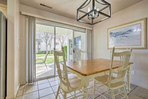 Enjoy meals in this dining area with a table and chairs, offering a view of the surrounding greenery.