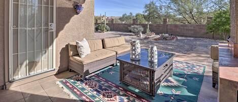 A patio with a sofa, a coffee table, and a patterned rug.