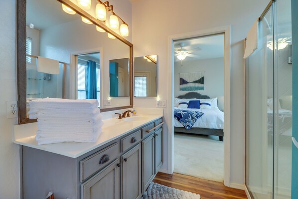 A modern bathroom with a large mirror, white sink, and stacked towels. - Mountain Views + Nearby Hikes: Gold Canyon Escape! (Gold Canyon)