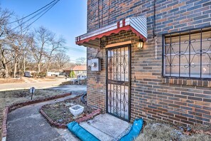 Stunning residential building with a brick facade and metal gate, set amidst a charming front yard with a concrete pathway.