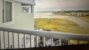 Een balkon met uitzicht op een rivier en een strand.