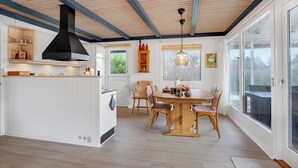 A modern kitchen with white cabinetry, a central island, and a large window. - 3 bedroom awesome home in Skjern (Skjern)