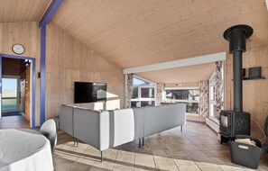 Relax in this spacious living room with a large flat-screen TV, comfortable sofa, and cozy fireplace.