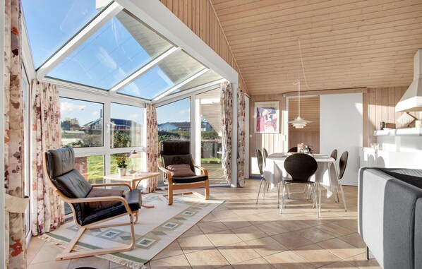 Relax in a spacious room with a comfortable seating area, dining table, and modern kitchen.