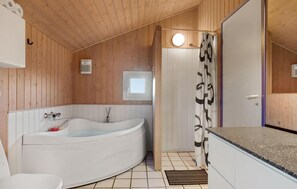 Une salle de bain moderne avec une baignoire sur pieds, des toilettes et un espace douche.