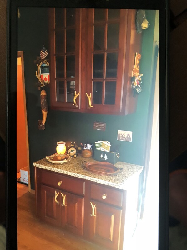 A kitchen with wooden cabinets, a granite countertop, and various kitchen items.