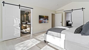 A bedroom with a bed, a painting, and a wardrobe.