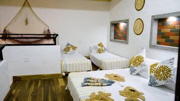 Una habitación con dos camas, una hamaca colgante y paneles decorativos en las paredes.