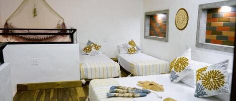 A room with two beds, a hanging net, and decorative wall panels.