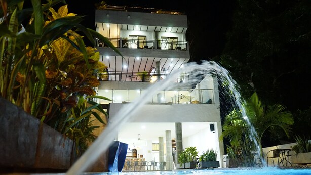 A multi-story building with a pool and water feature in front. - HONDA COLONIAL MAGDALENA RESORT (Honda)