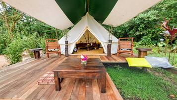 Relax in a tranquil outdoor tent with a deck and comfortable seating.