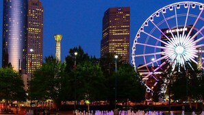 A cityscape with a prominent Ferris wheel and modern skyscrapers. - Popular Filming Area- Downtown Atlanta Condo (atlanta)