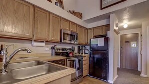 A kitchen with wooden cabinets, stainless steel appliances, and a sink.