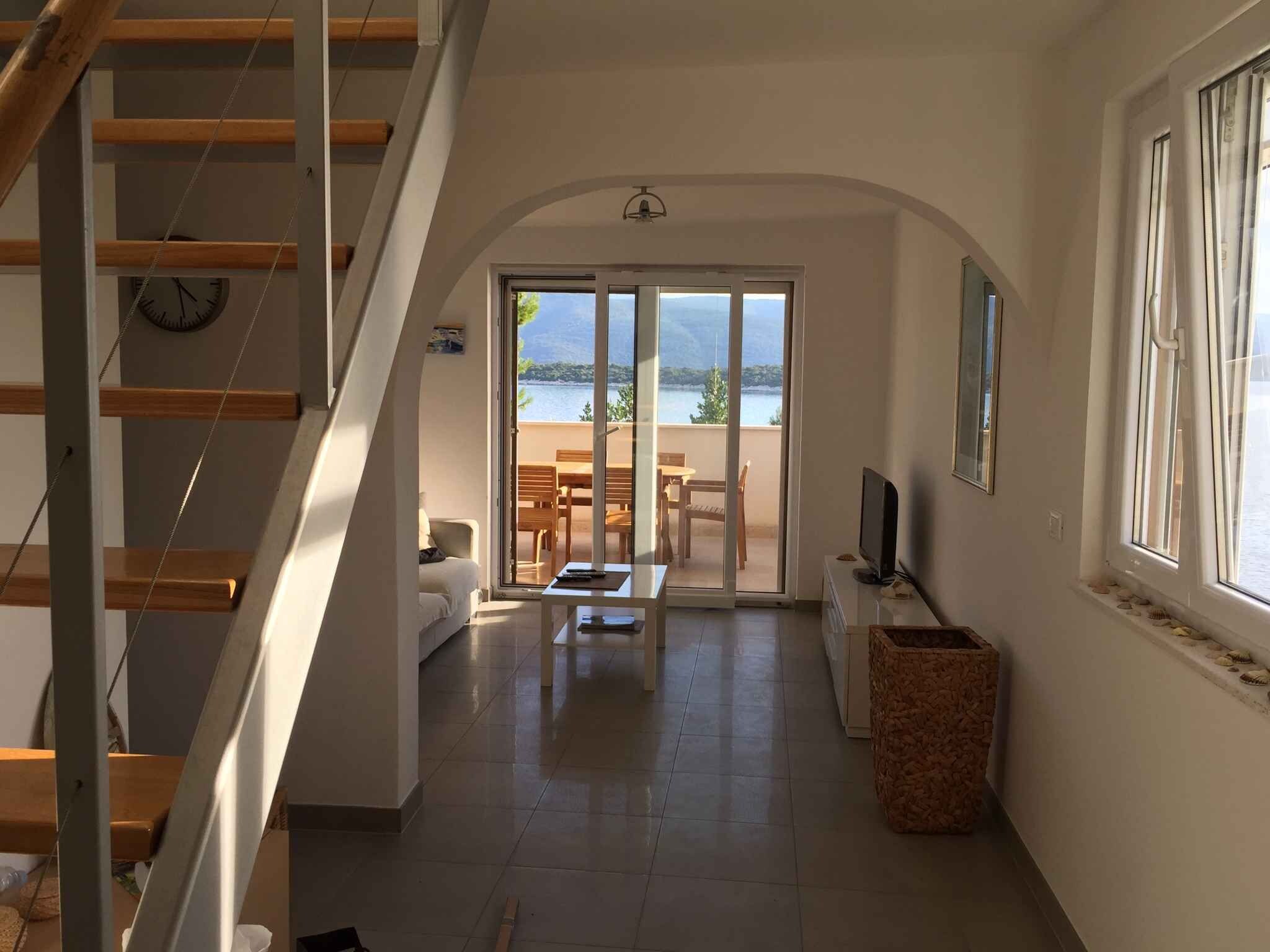 Un vaste espace de vie comprenant un escalier, un canapé, une table basse et un téléviseur.