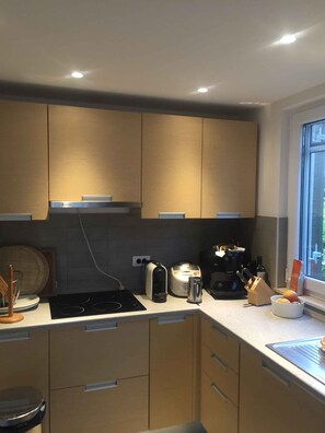 A modern kitchen with built-in appliances, a window, and a view of the outdoors. - Holiday apartment "Male" penthouse (Klek)