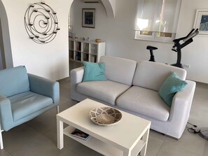 A living room with a sofa, a coffee table, and a wall-mounted light fixture. - Holiday apartment "Male" penthouse (Klek)