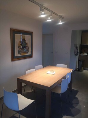 A modern dining area with a wooden table, six chairs, and a framed artwork on the wall. - Holiday apartment "Male" penthouse (Klek)