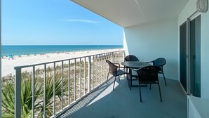 Een balkon met uitzicht op een strand en de oceaan.