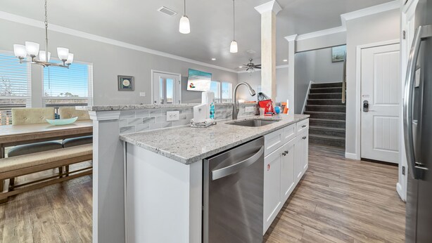A modern kitchen with a central island, stainless steel appliances, and pendant lighting. - Attitude Adjustment-CONVENIIENT LOCATION, PRIVATE POOL, GREAT FOR FAMILIES! (Gulf Shores)