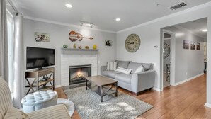 Ein Wohnzimmer mit Kamin, einer Couch, einem Couchtisch und einem Fernseher.
